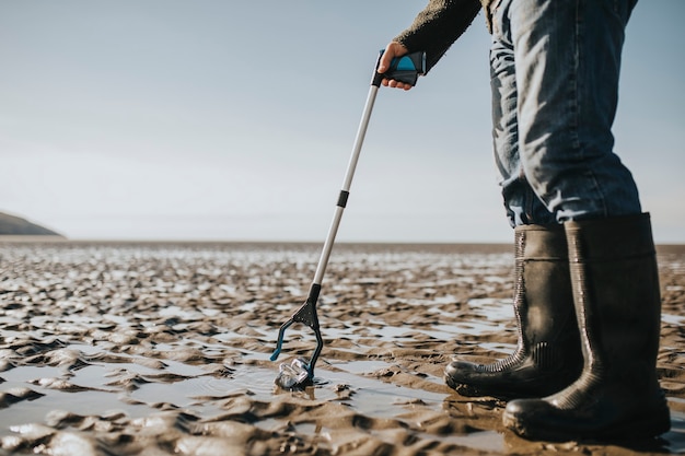 Voluntários de limpeza de praia catando lixo para campanha ambiental