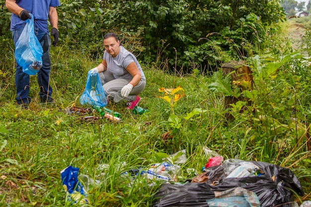 Los voluntarios eliminan la basura de un vertedero en la naturaleza. Foto horizontal