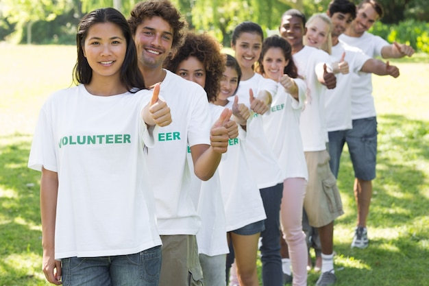 Voluntarios gesticulando pulgar arriba en el parque