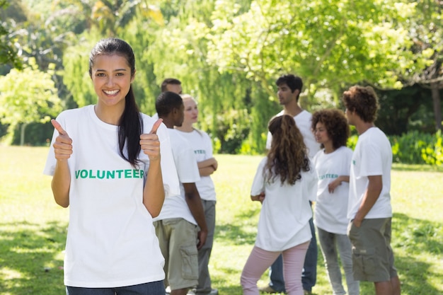 Voluntarios gesticular pulgares arriba en el parque