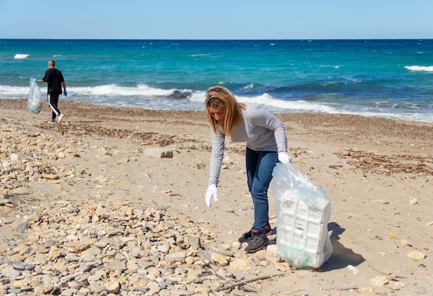 Voluntários limpando a área da praia de plástico