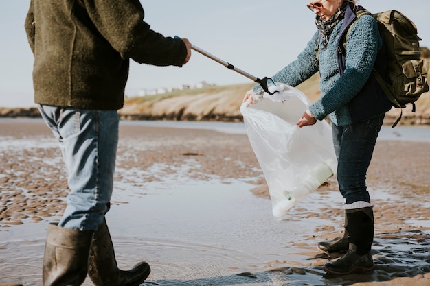 Voluntarios de limpieza de playas recogiendo basura para la campaña ambiental