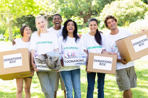 Voluntários que transportam caixas de doação no parque