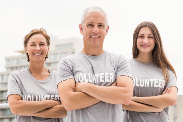 Voluntarios sonrientes con los brazos cruzados