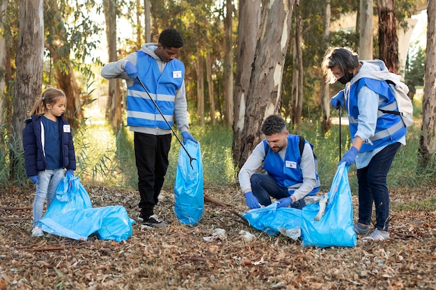 Voluntarios de tiro completo recogiendo basura