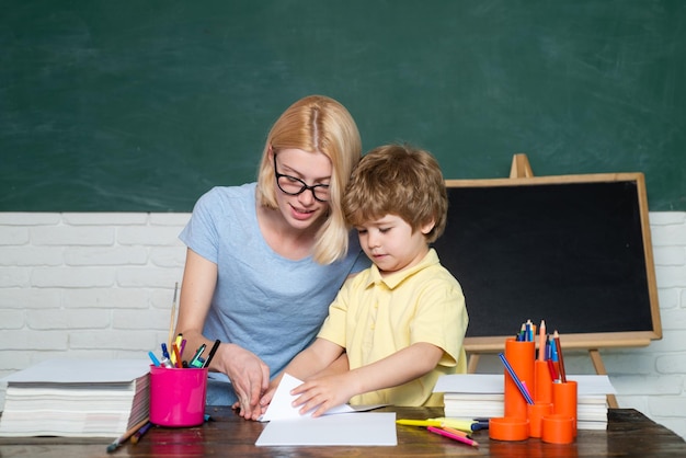 Volver al proceso educativo de la escuela gran logro de estudio niño y maestro cerca de la pizarra en la escuela ...