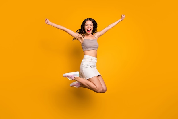 Volvió la foto del tamaño del cuerpo de longitud completa de una mujer alegre y emocionada que gritaba sí ganando el premio aislado fondo de colores vivos