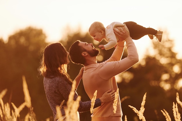 Vom Sonnenlicht beleuchtet Glückliche Familie der Mutterfamilie und des kleinen Babys ruht im Freien Schöne sonnige Herbstnatur