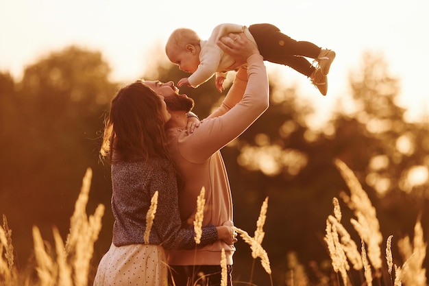 Vom Sonnenlicht beleuchtet Glückliche Familie der Mutterfamilie und des kleinen Babys ruht im Freien Schöne sonnige Herbstnatur
