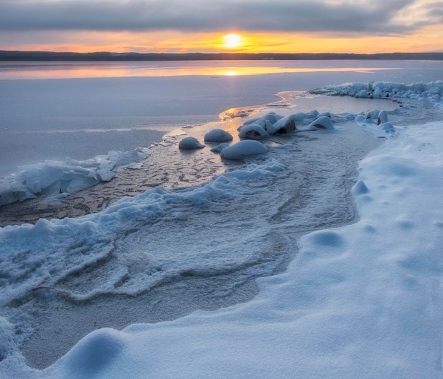 Von Eis und Schnee umschlossener See bei Sonnenuntergang im Winter