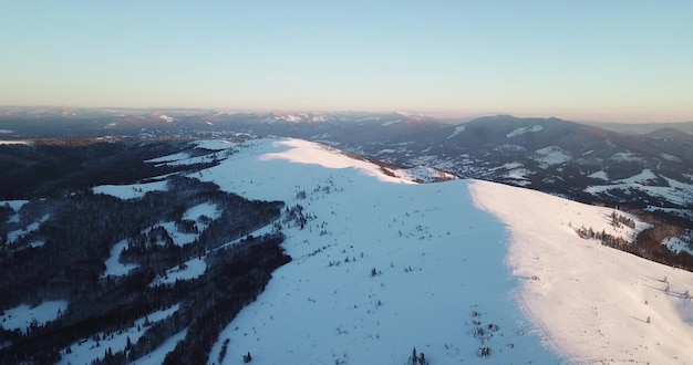 Von großer Höhe märchenhafte Berglandschaft schneebedeckte alpine scharfe Gipfel Wilder Winter in den Karpaten Ukraine Dicke weiße Wolken Freiraum Antenne 4K