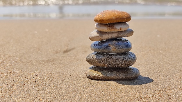 Von Hand angelegte Zen-Steine, die auf Sand des Meeresstrandes liegen