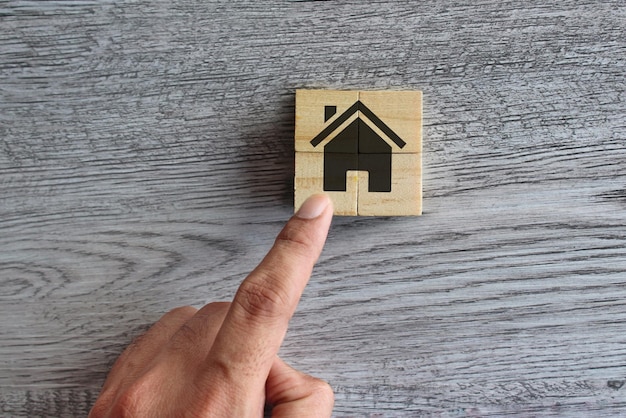Von Hand gelegte Holzwürfel, um ein Haus zu bauen. Bauen Sie ein Traumhaus, ein ideales Hauseigentumskonzept