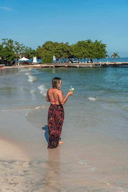 Von hinten: Frau am Strand morgens