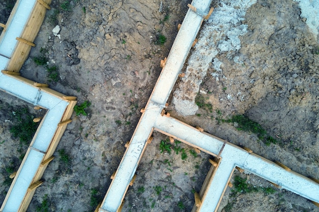 Von oben nach unten Luftaufnahme der Bauarbeiten des neuen Hausbetonfundaments auf der Baustelle.