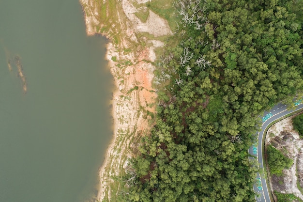 Von oben nach unten von Dam Lake Mountains mit waldgrünem Muster schöner sonniger Tag Sommerwetter Drone Shot Luftbild Wolken Bewässerung Naturumgebung.