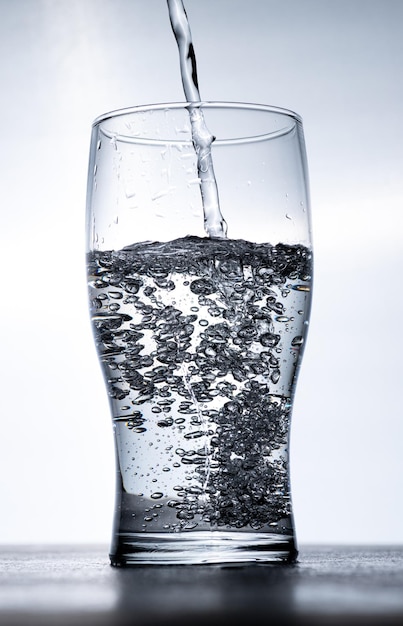 Foto von oben wird wasser in ein glas gegossen