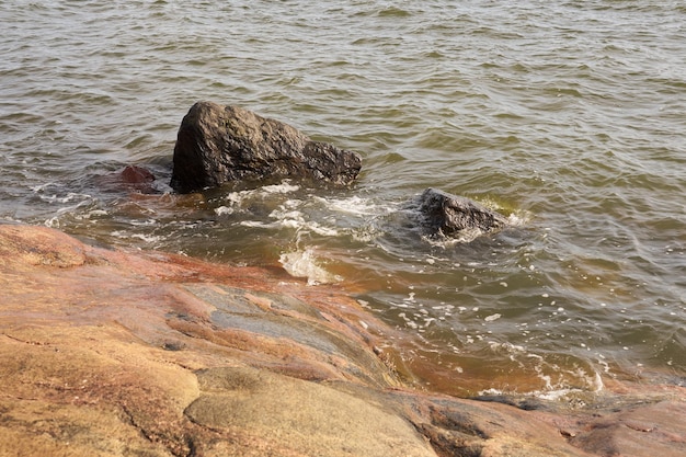 Von Wellen umspülte Granitsteine an der felsigen Küste der Ostsee