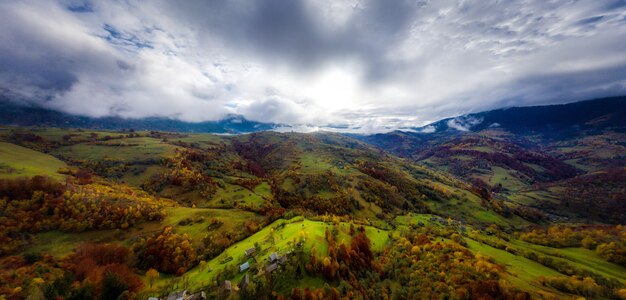 Voo através do céu azul com nuvens sobre a montanha