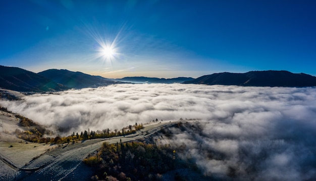 Voo através do céu azul com nuvens sobre a montanha