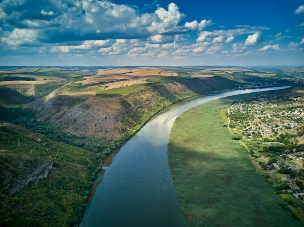 Voo através do majestoso rio Dnister, exuberante floresta verde e vila. Moldávia, Europa. Fotografia de paisagens.