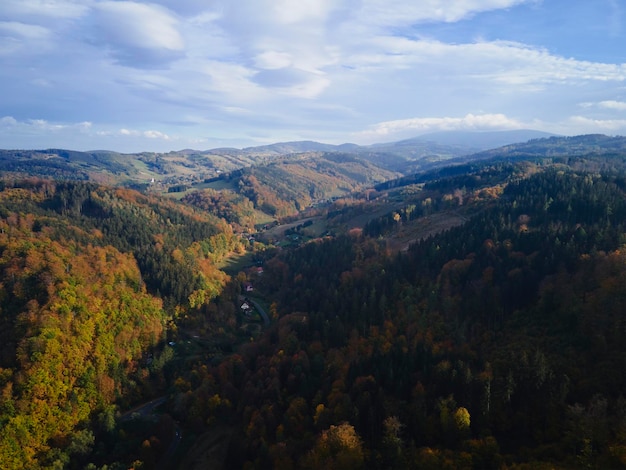 Voo de drone sobre montanhas cobertas de floresta na temporada de outono bela paisagem natural