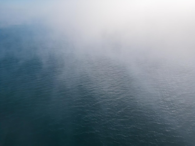 Voo de drone sobre o mar no nevoeiro da manhã