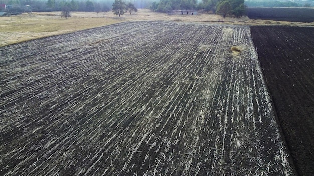 Vôo de visão aérea de drone sobre campo de campos arados de terra marrom arada