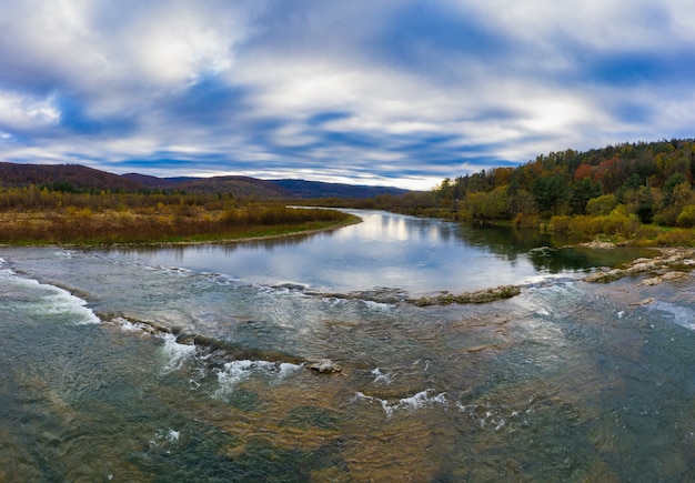 Voo sobre o outono do rio da montanha, folhas coloridas e o riacho Striy nas montanhas dos Cárpatos