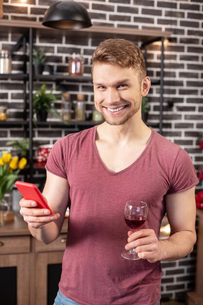 Vor dem abendessen. bärtiger, strahlender blonder ehemann, der vor einem romantischen abendessen mit seiner frau aufgeregt ist