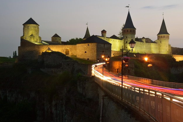 Vor dem Hintergrund der Nachtfestung Spuren von Scheinwerfern von Autos, die über die Brücke fahren