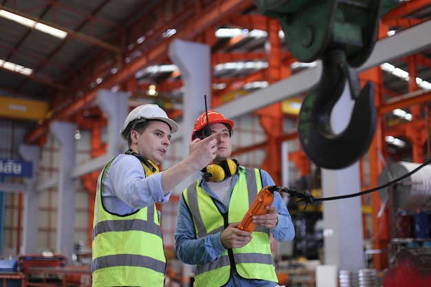 Vorarbeiter oder Arbeiter arbeiten am Fabrikstandort und überprüfen Maschinen oder Produkte vor Ort. Ingenieur oder Techniker überprüfen Material oder Maschine in der Industrie- und Fabrikanlage