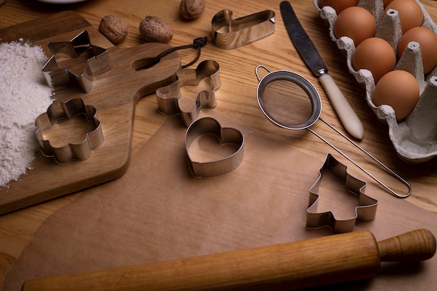 Vorbereitung auf Weihnachten. alles für Lebkuchen - Formen, Mehl, Eier auf einem Holztisch