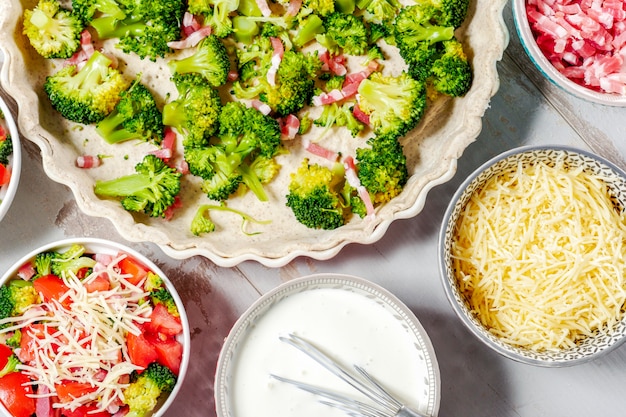 Vorbereitung der französischen Quiche mit Tomaten und Brokkoli