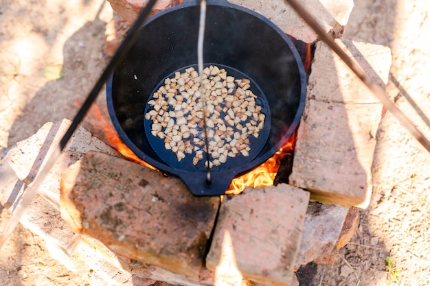 Vorbereitung des raditionellen armenischen Pilaws in einem Kessel am offenen Feuer.