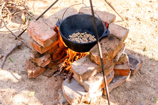 Vorbereitung des raditionellen armenischen Pilaws in einem Kessel am offenen Feuer.