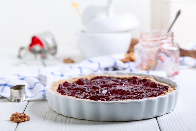 Vorbereitung eines Shortcrust-Kekskuchen mit Beerenmarmelade zum Backen