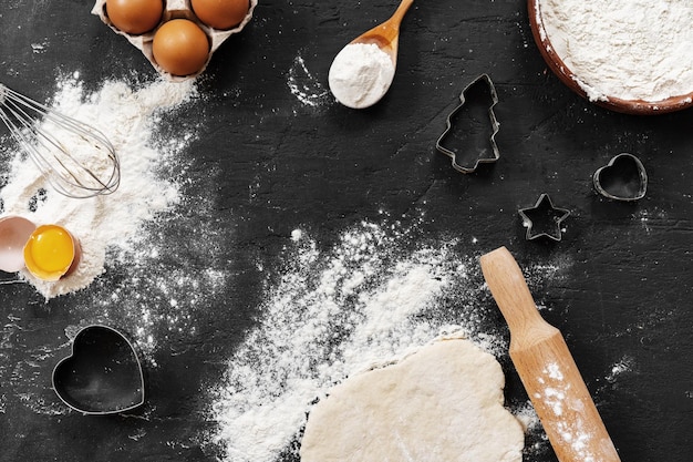 Foto vorbereitung zum backen eier und mehl auf schwarzem hintergrund