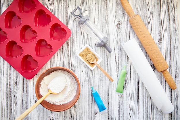 Vorbereitung zum Backen mit herzförmiger Silikonform Valentinstag-Konzept