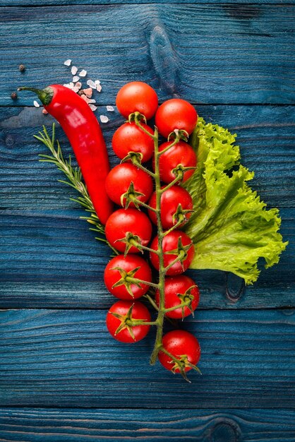 Vorbereitung zum Kochen Cherry Tomaten Frisches Gemüse und Gewürze auf einem hölzernen Hintergrund Ansicht von oben