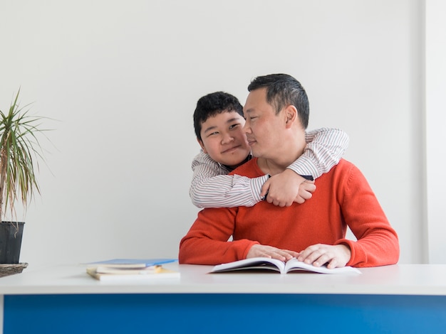 Vorderansicht asiatischen Vater und Sohn umarmen