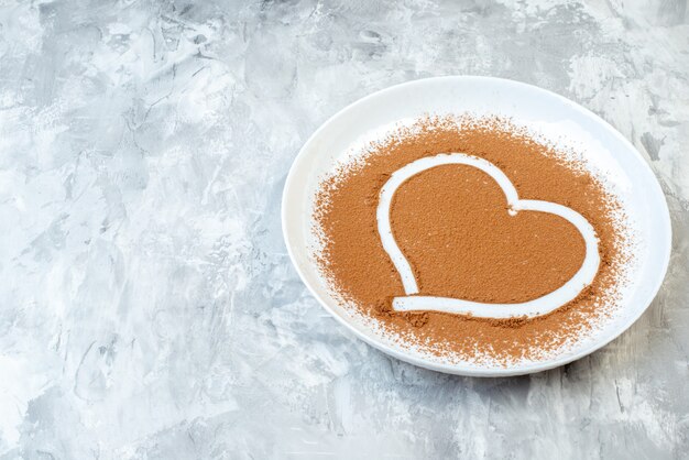 Foto vorderansicht braunes mehl in herzform innenplatte auf weißem hintergrund kuchen backen eifarbe geschmack kuchen foto essensstaub