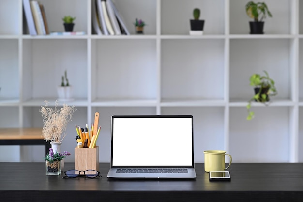 Vorderansicht-Computer-Laptop mit leerem Display, Kaffee und Bleistifthalter auf Holztisch.