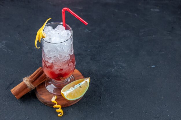 Vorderansicht cooler Fruchtcocktail mit Strohhalm und Eis auf dunklem Hintergrund Limonade Sommerbar Eissaft Party trinken frische Farben