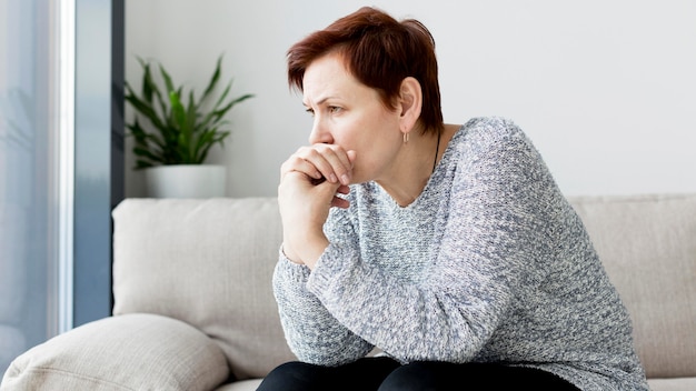 Vorderansicht der Frau, die auf Couch sitzt