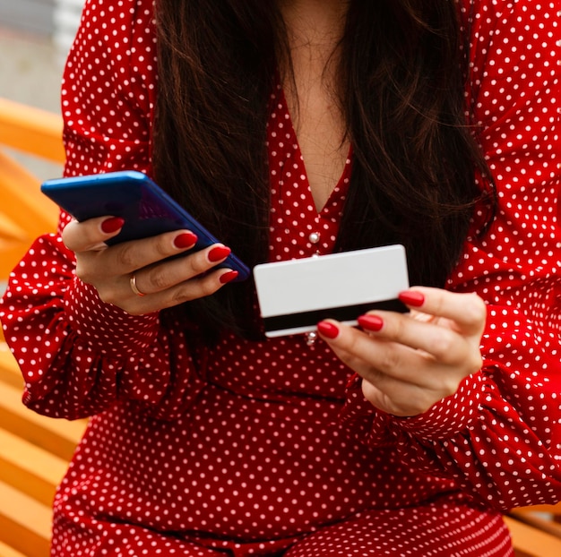 Foto vorderansicht der frau, die smartphone und kreditkarte verwendet, um verkäufe online einzukaufen