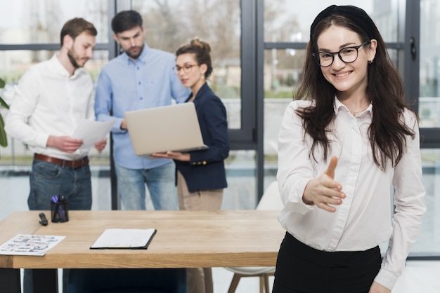 Foto vorderansicht der frau im büro, die händedruck anbietet