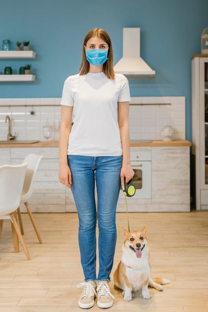 Foto vorderansicht der frau mit der medizinischen maske und ihrem hund in der leine