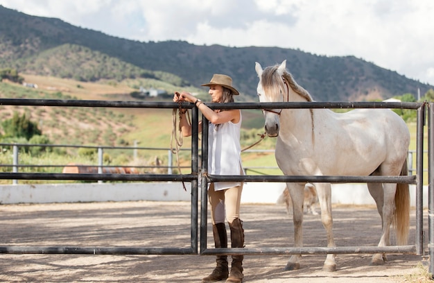 Vorderansicht der Landwirtin mit ihrem Pferd auf der Ranch