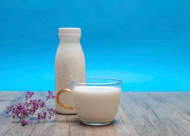 Foto vorderansicht der milch in der tasse mit flasche und kopienraum